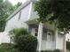 Shows the side exterior with light blue vinyl siding, a white front door, and manicured landscaping at 215 Silver Spring St, Dallas, GA 30157