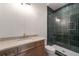 Stylish bathroom with a stone countertop, walk-in shower with dark green tile, and modern fixtures at 4091 Oak Forest Drive Ne, Brookhaven, GA 30319