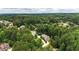 Brick home featuring lush landscaping, long driveway and set in a beautiful wooded community from an aerial perspective at 4995 Aviary Nw Dr, Acworth, GA 30101