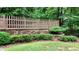 Grassy backyard featuring a decorative retaining wall, small garden, and a wooden fence at 4995 Aviary Nw Dr, Acworth, GA 30101