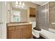 Bathroom with granite counters, wood cabinets, a tub with shower, and updated fixtures at 4995 Aviary Nw Dr, Acworth, GA 30101