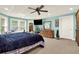 Large bedroom with a ceiling fan, blue accent wall, three windows, and light carpet at 4995 Aviary Nw Dr, Acworth, GA 30101
