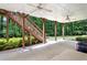 Spacious covered patio with ceiling fans, wooden support beams, and steps leading to the upper deck at 4995 Aviary Nw Dr, Acworth, GA 30101