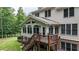 Back of the home featuring a deck, sunroom with large windows, and well-maintained landscaping at 4995 Aviary Nw Dr, Acworth, GA 30101