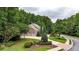 Scenic view of a home with lush landscaping, mature trees, and a long driveway at 4995 Aviary Nw Dr, Acworth, GA 30101