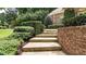 A set of concrete stairs bordered by a brick retaining wall with lush landscaping and greenery at 4995 Aviary Nw Dr, Acworth, GA 30101
