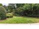 Mature landscaping surrounds this lush green lawn with flowering bushes and mature shade trees at 4995 Aviary Nw Dr, Acworth, GA 30101