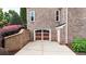 Attached two-car garage featuring paneled doors, windows, and a brick facade at 4995 Aviary Nw Dr, Acworth, GA 30101