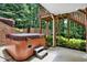 Outdoor hot tub on a stone patio with privacy fencing and landscaping at 4995 Aviary Nw Dr, Acworth, GA 30101