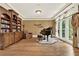 Elegant room with hardwood floors, built-in bookcase, grand piano, and arched windows at 4995 Aviary Nw Dr, Acworth, GA 30101