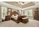 Luxurious main bedroom featuring a tray ceiling, plush carpet, and large windows at 4995 Aviary Nw Dr, Acworth, GA 30101