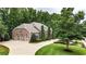 Spacious home exterior with a three-car garage, lush landscaping, and expansive driveway at 4995 Aviary Nw Dr, Acworth, GA 30101