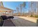 Expansive backyard with a covered patio, lush lawn, and mature trees at 5365 Vendelay Ln, Cumming, GA 30040