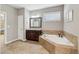 Bathroom features a jacuzzi tub, ceramic tile, and dark wood vanity with granite countertop at 5365 Vendelay Ln, Cumming, GA 30040