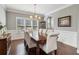 Formal dining room featuring a large wooden table, elegant chairs, wainscoting, and ample natural light at 5365 Vendelay Ln, Cumming, GA 30040