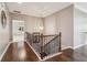 Upstairs hallway featuring hardwood floors and decorative wrought iron railing at 5365 Vendelay Ln, Cumming, GA 30040