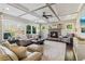 Comfortable living room with a stone fireplace, coffered ceiling, hardwood floors, and natural light, perfect for gatherings at 5365 Vendelay Ln, Cumming, GA 30040