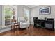 Cozy home office featuring a large window for natural light, hardwood floors, and ample workspace for productivity at 5365 Vendelay Ln, Cumming, GA 30040