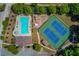 Aerial view of community pool, tennis courts, and playground nestled amongst lush green trees at 836 Windsor Place Ct, Grayson, GA 30017