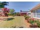 View of the backyard and brick home featuring manicured landscaping and trees at 836 Windsor Place Ct, Grayson, GA 30017