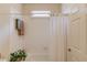 Bathroom with a combination tub and shower featuring a white curtain and white wall tiling at 836 Windsor Place Ct, Grayson, GA 30017