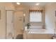 Bright bathroom featuring a soaking tub, a tiled shower, and neutral wall paint at 836 Windsor Place Ct, Grayson, GA 30017