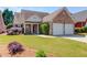 Well-kept brick home with a two-car garage, lush lawn, and inviting front porch at 836 Windsor Place Ct, Grayson, GA 30017