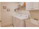 Clean laundry room with white washer and dryer, a utility sink, and wire shelving for storage at 836 Windsor Place Ct, Grayson, GA 30017