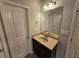 Bathroom features a single sink vanity with updated fixtures and decorative mirror at 1021 Rock Elm Dr, Auburn, GA 30011