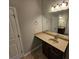 Bathroom vanity with tan countertop, dark wood cabinets, large mirror, and ample lighting at 1021 Rock Elm Dr, Auburn, GA 30011