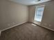 Bedroom with neutral colored walls, carpet flooring and a window at 1021 Rock Elm Dr, Auburn, GA 30011