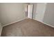Bedroom with carpet flooring and neutral colored walls with an open doorway and closed door at 1021 Rock Elm Dr, Auburn, GA 30011