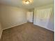 A neutral-toned bedroom with carpeted floors and a double door closet offers simple elegance at 1021 Rock Elm Dr, Auburn, GA 30011