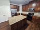 Traditional kitchen features wooden cabinets, granite counters, an island, and stainless-steel appliances at 1021 Rock Elm Dr, Auburn, GA 30011