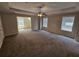 Spacious main bedroom featuring a tray ceiling, ceiling fan, and multiple windows at 1021 Rock Elm Dr, Auburn, GA 30011