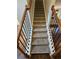 Carpeted staircase with stained wood handrail and decorative black metal spindles at 1021 Rock Elm Dr, Auburn, GA 30011