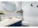 Cozy bathroom featuring blue vanity with white countertop, oval mirror and decorative heart-shaped wall décor at 1879 Beaver Dam Ne Ln, Marietta, GA 30062