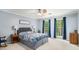 Spacious bedroom boasts a ceiling fan, large windows with blue curtains, and a comfortable bed at 1879 Beaver Dam Ne Ln, Marietta, GA 30062
