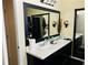 Dual sink bathroom with white counters, black cabinets, and a large framed mirror at 5814 Highgrove Dr, Atlanta, GA 30349