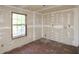 Bedroom featuring unfinished drywall, a window with view, and a worn floor at 1112 Mountain Springs Nw Dr, Kennesaw, GA 30144