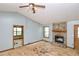 Living room features a stone fireplace, ceiling fan, and natural light from two windows at 1112 Mountain Springs Nw Dr, Kennesaw, GA 30144