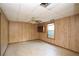 Spacious living room featuring wood-paneled walls, suspended ceiling, and a ceiling fan with light fixture at 1112 Mountain Springs Nw Dr, Kennesaw, GA 30144