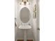 Charming powder room featuring a pedestal sink, decorative mirror, and classic finishes at 1227 Parkside Village Nw Dr, Marietta, GA 30060