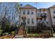 Inviting three-story brick townhome with manicured front yard, steps, and black metal fence at 124 Everley Walk, Alpharetta, GA 30009