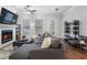 Cozy living room featuring a fireplace, plush sectional sofa, and abundant natural light at 124 Everley Walk, Alpharetta, GA 30009