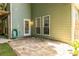 Outdoor stone patio area with green siding, white door, and hose on side of home at 1100 Ashbury Dr, Decatur, GA 30030