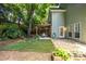 Serene fenced backyard with mature trees, an artificial lawn, and a stone patio with pergola at 1100 Ashbury Dr, Decatur, GA 30030