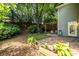 Fenced backyard with lush landscaping, pergola-covered seating area, and stone patio at 1100 Ashbury Dr, Decatur, GA 30030