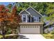 Charming two-story home with a well-maintained lawn and a two car garage and colorful tree at 1100 Ashbury Dr, Decatur, GA 30030