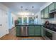 Kitchen with stainless steel appliances, custom green cabinets, and a black countertop island at 1100 Ashbury Dr, Decatur, GA 30030